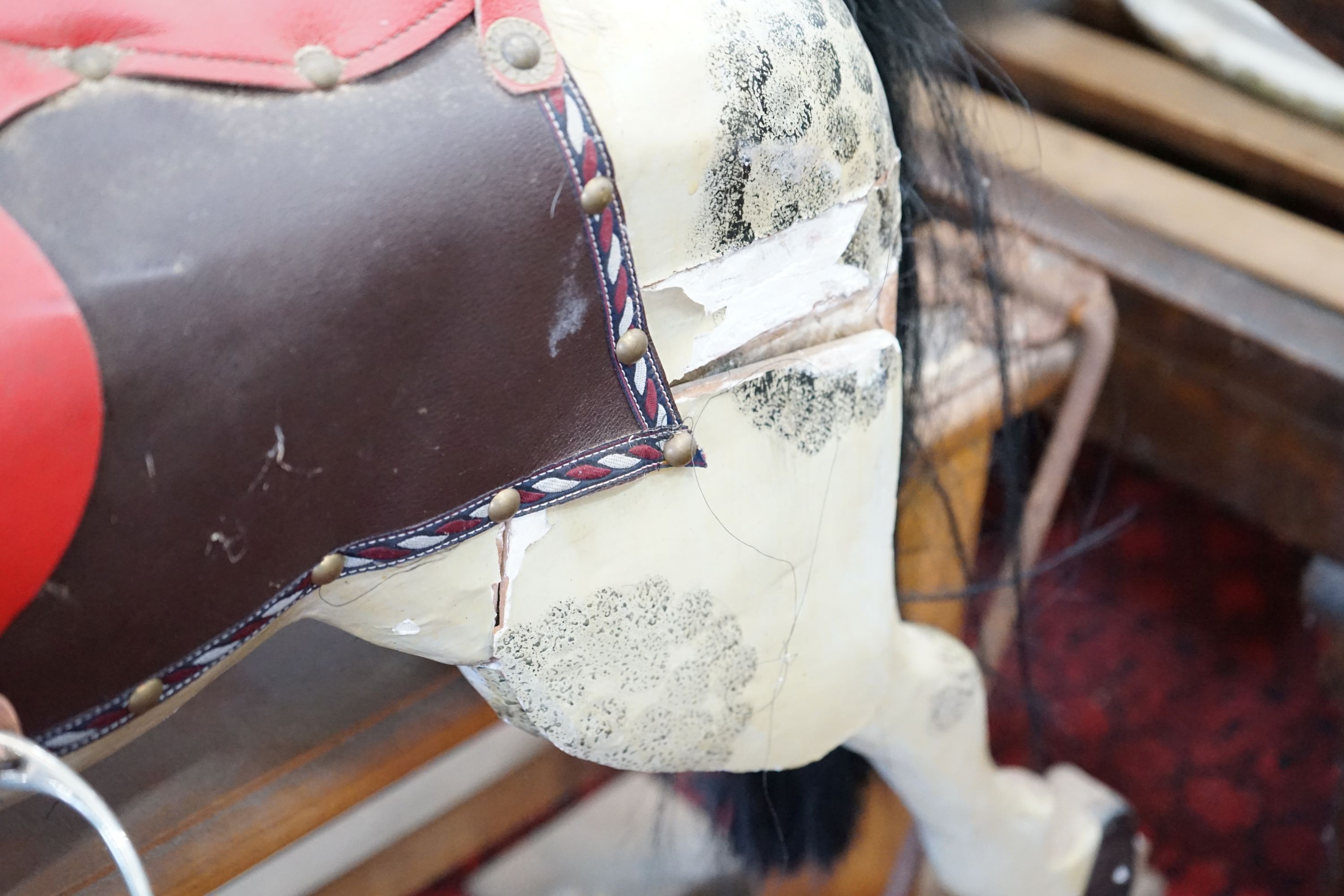 An Ayres type dappled rocking horse on pine safety frame, length 135cm